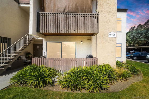 Front view of a multi-story residential building with a balcony and entrance area.