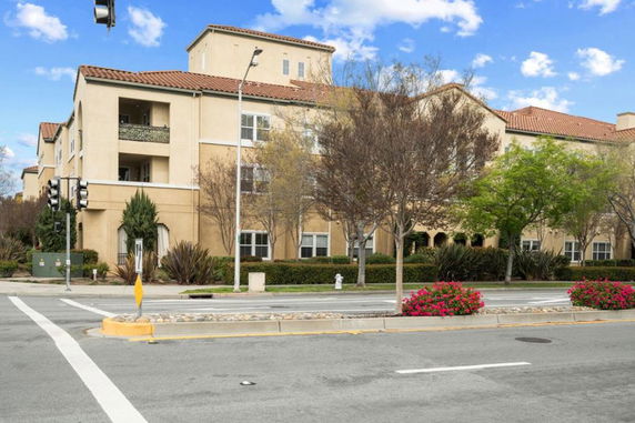 Front view of a multi-story building with beige exterior and red-tiled roof.