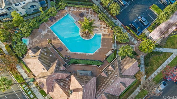 Aerial view of a swimming pool surrounded by buildings and greenery.