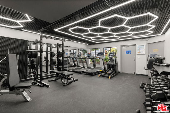 Interior view of a gym with fitness equipment and modern lighting.