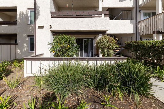 Front view of a multi-story building with balconies and enclosed patio areas.