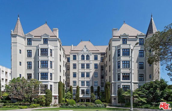 Front view of a multi-story building with a symmetrical design and pointed roofs.