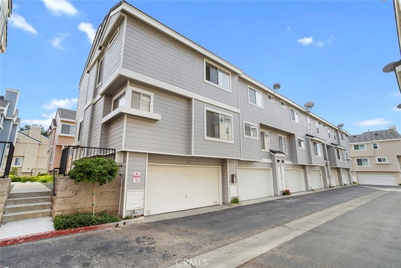 Front view of a multi-story residential building with garages.