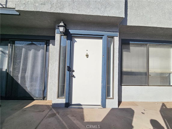 Front view of a building entrance with a white door and blue frame.