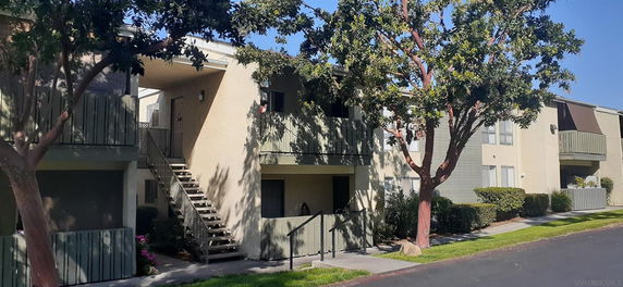 Front view of a two-story apartment building with balconies.
