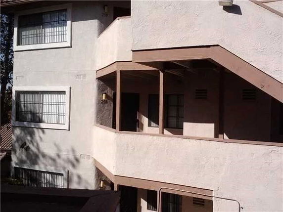 Exterior view of a multi-story building with balconies and large windows.