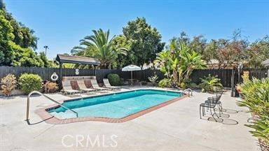 Outdoor area featuring a swimming pool surrounded by lounge chairs and plants.