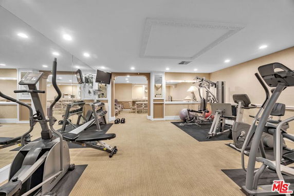 Indoor gym area with exercise equipment and mirrors.