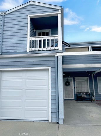 Front view of a two-story house with a garage and balcony.