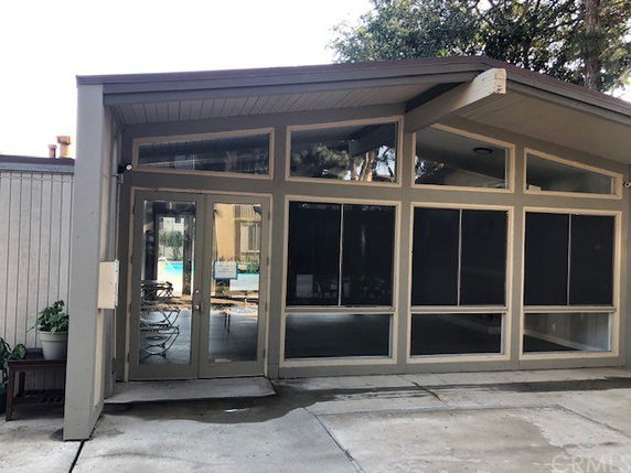 Front view of a single-story building with large windows and a glass door.