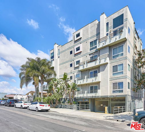Front view of a multi-story apartment building with balconies.