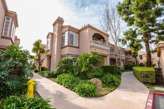 Front view of a two-story house with balconies and landscaped path.