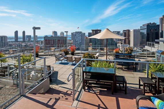 Rooftop area with seating and umbrella offering city views.