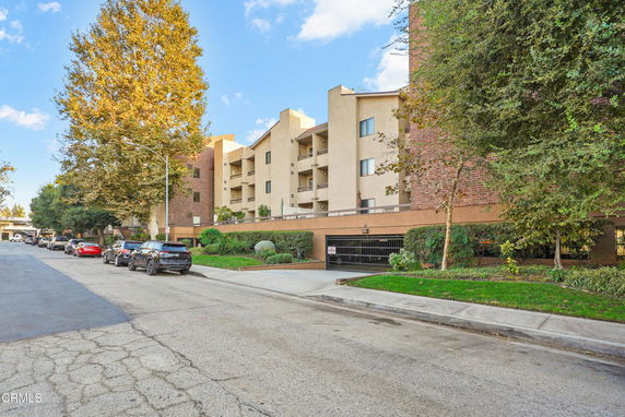 Front view of a multi-story building with balconies and brick accents.