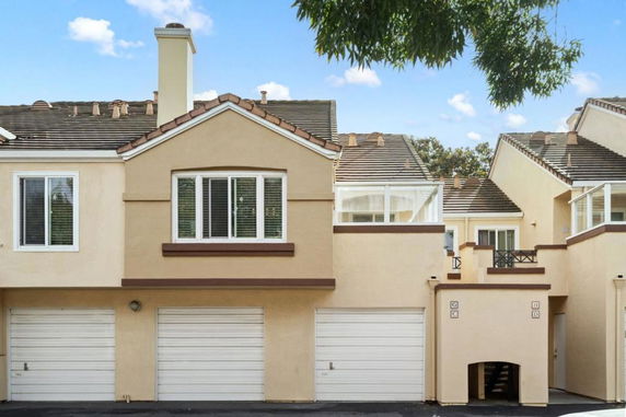 Front view of a multi-story townhouse with a two-car garage and balcony.