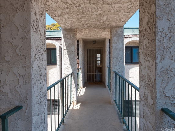 Front view of an apartment entry corridor with stucco walls.