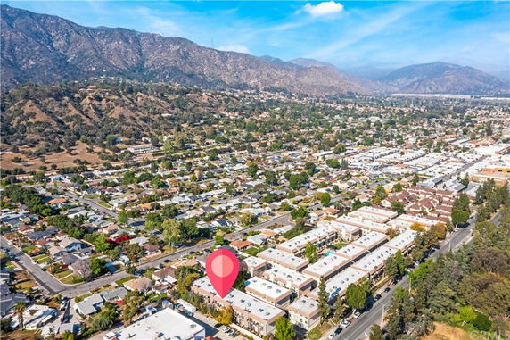 Aerial view of a residential area with mountains in the background.