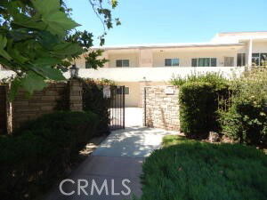 Front view of a two-story building with a gated entrance and path.