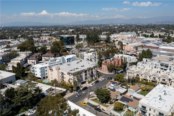 Aerial panoramic view of a suburban area with multiple residential buildings and surrounding landscape.