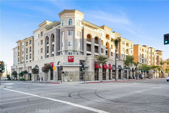 Front view of a multi-story building with commercial establishments on the ground floor.