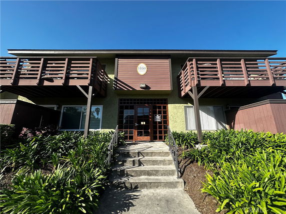 Front view of a two-story building with wooden balconies.