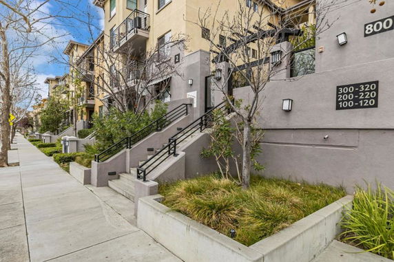 Front view of a multi-story apartment building with staircases and small balconies.