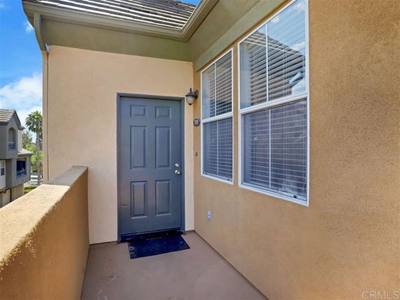 Front view of a house entrance with a gray door and adjacent windows.