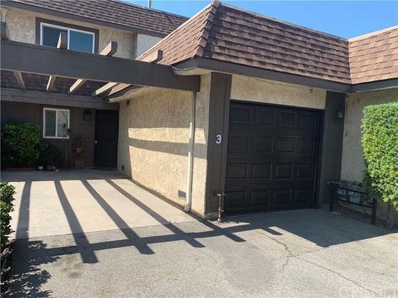 Front view of a house with a single garage and pergola.