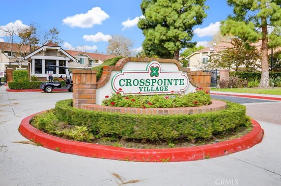 Front view of a residential community entrance with sign.