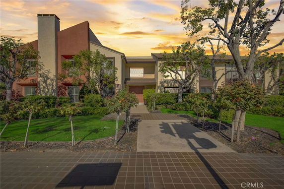 Front view of a building with a modern design and landscaped garden.