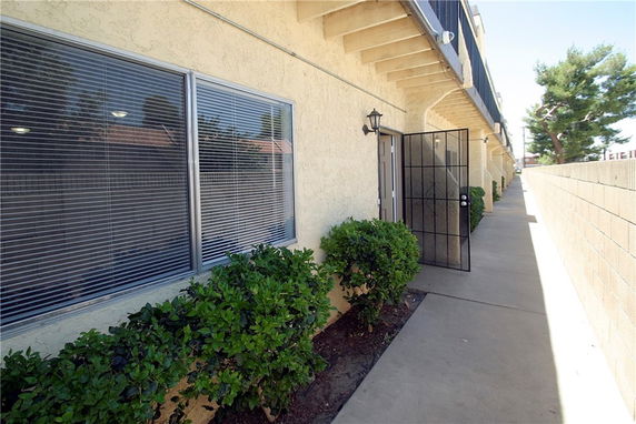 Side view of a building with windows and a small garden area.