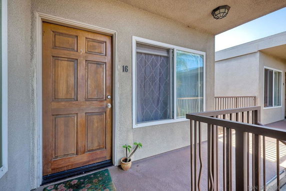 Front elevation of an apartment unit with a wooden door and a window.