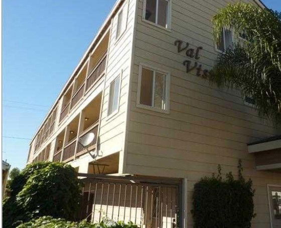 Front view of a three-story apartment building with balconies.