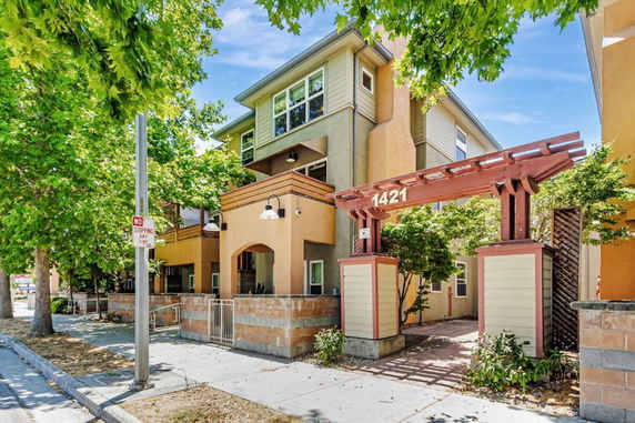Front view of a multi-story building with an entrance archway and house number displayed.