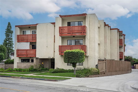 Front view of a multi-story apartment building with balconies.