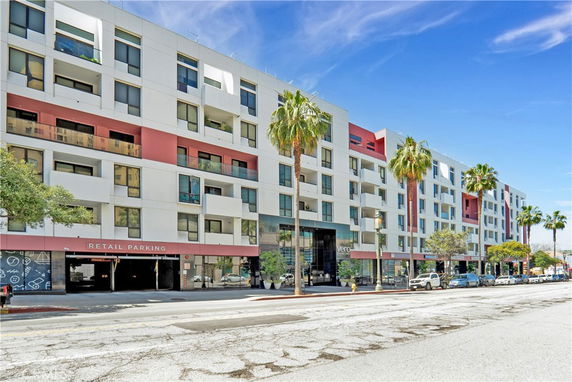 Front view of a multi-story building with retail parking.