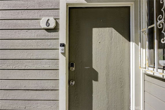 Front view of a house entrance with a numbered door and doorbell.