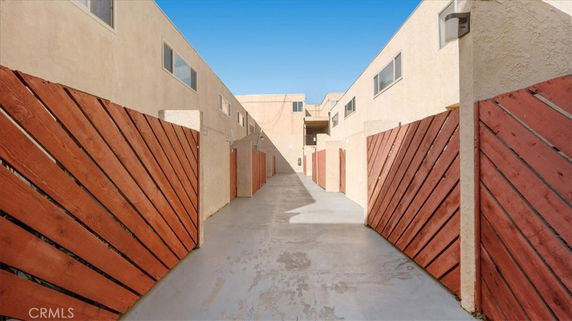 Front view of a building with an enclosed walkway and wooden fences.