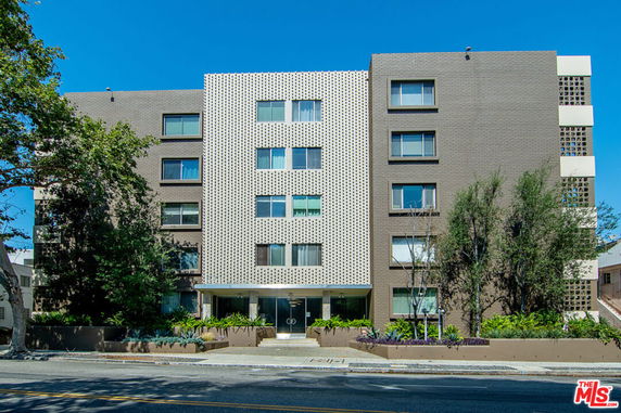 Front view of a multi-story apartment building with a patterned facade.
