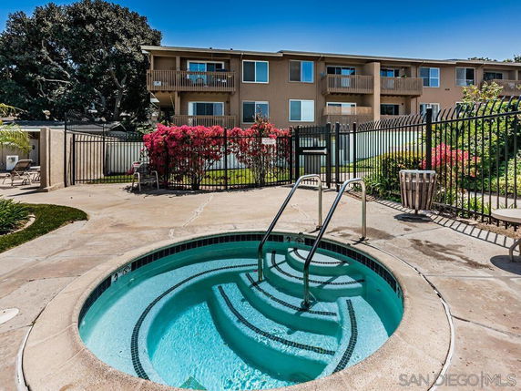 Outdoor area with a small round swimming pool near a residential building.