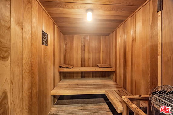 Interior view of a wooden sauna room with benches and a heater.