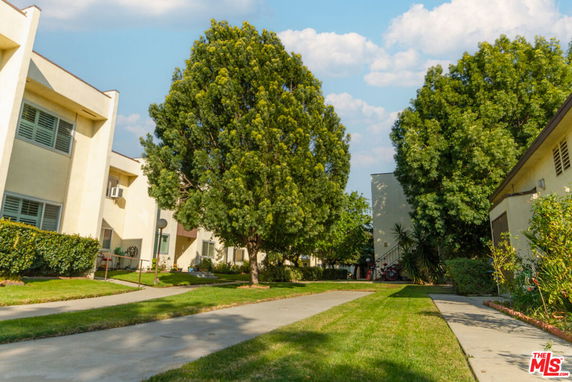 View of multiple residential buildings with trees and lawns.