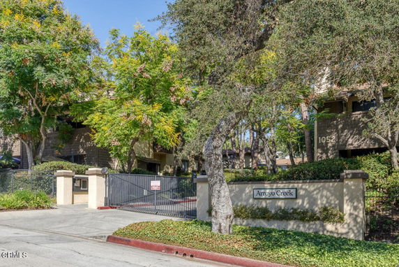 Front view of a building with gated entry and trees.