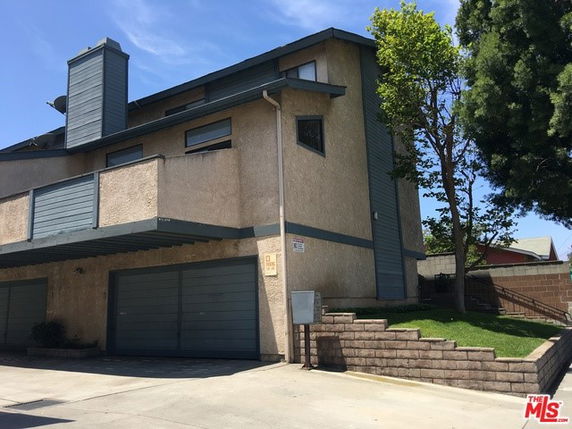 Front view of a multi-story house with a double garage and chimney.