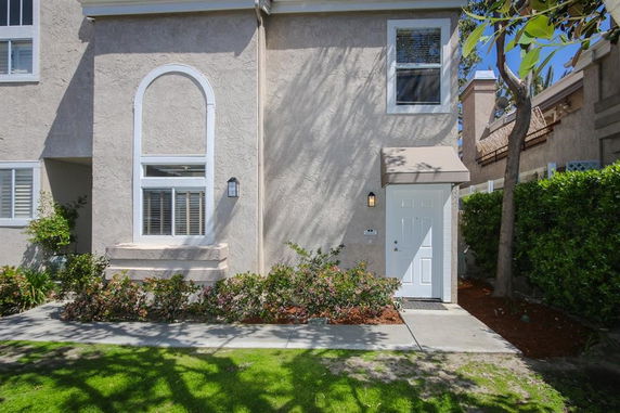 Front view of a two-story house with a prominent arched window and entrance door.