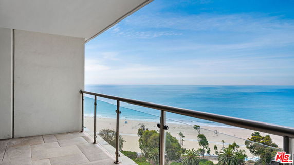 Panoramic view from a balcony overlooking a beach and ocean.