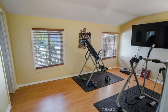 Room with exercise equipment including an inversion table and elliptical machine.