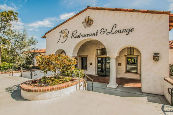 Front view of a restaurant with an arched entrance and sign reading 'Restaurant & Lounge'.