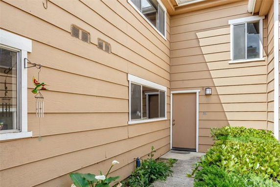 Exterior view of a two-story building with a beige facade and a brown door.