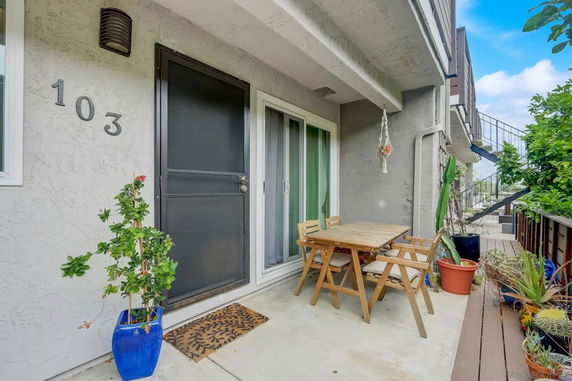 Front view of a house entrance with a patio area and outdoor seating.